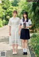 Two young women in school uniforms standing next to each other.