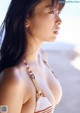 A woman in a bikini standing on a beach.