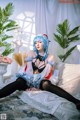 A woman with blue hair sitting on a couch.