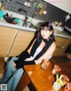 A woman sitting at a table in a kitchen.